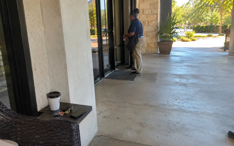 Leasing office entrance with glass doors and a covered walkway, no people present