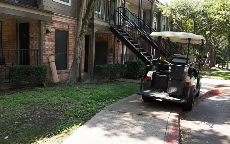 Three-story garden-style apartment exterior with red brick and breezeway stairs