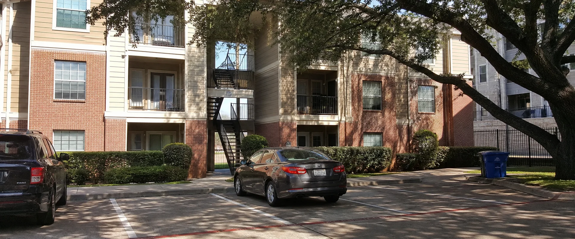 Garden-style Fort Worth apartment building seen from the parking lot on an overcast afternoon