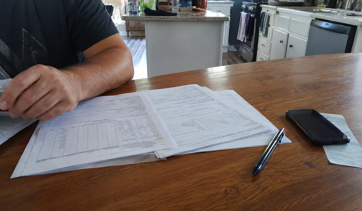 Income certification paperwork for a Fort Worth tax-credit apartment beside a household size worksheet
